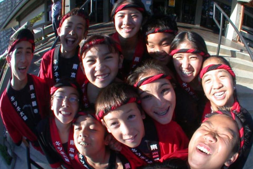 Group of students of Kitsune Taiko gather around for a photo in a fisheye lens